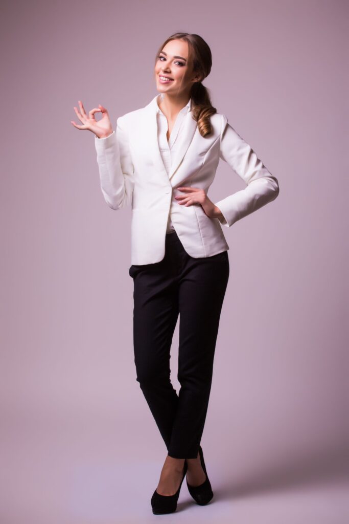 happy smiling beautiful young businesswoman showing okay gesture grey wall caucasian blond model business presentation concept square composition 1